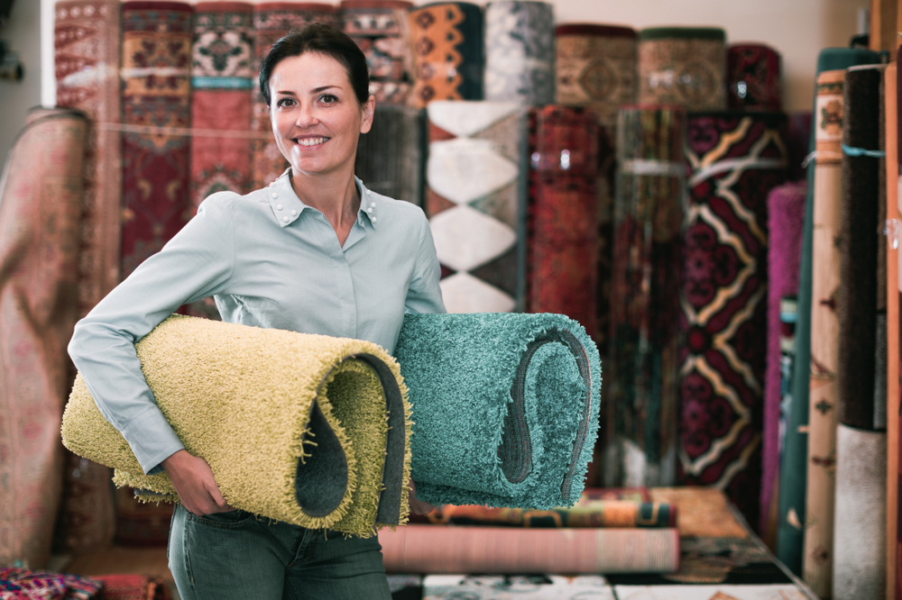 A girl choosing and laying area rugs in the home