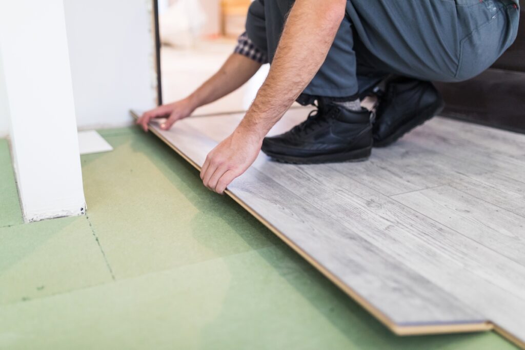 worker installs lvp flooring for home